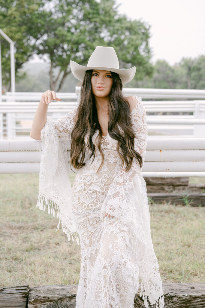 Bride resting hand on fence post at The Videre wedding venue in western editorial styling