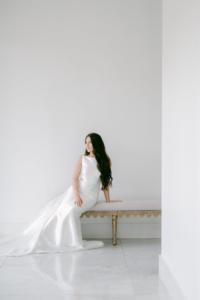 Bride reclining on upholstered bench at The Videre wedding venue with soft natural light