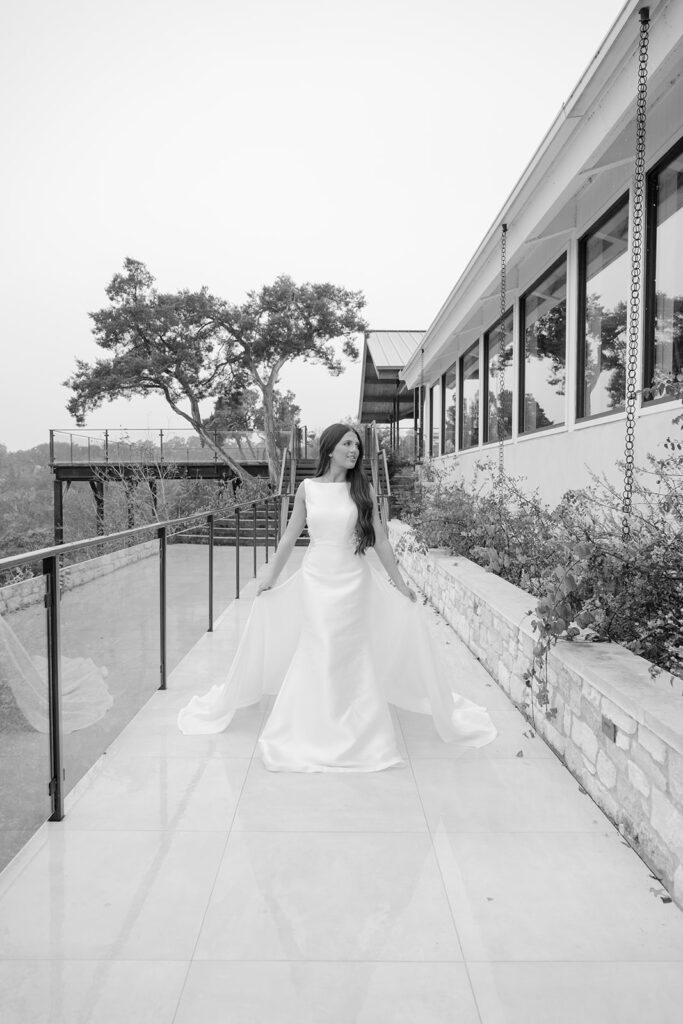 Black and white image of bride walking along elevated garden terrace at The Videre