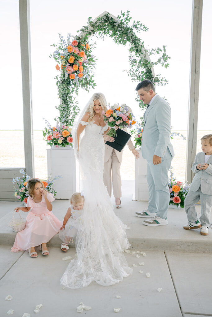 Couple walking back down the aisle with children after ceremony at The Allen Farmhaus