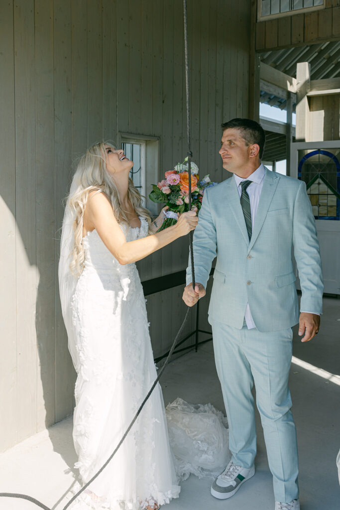 Bride laughing while holding bouquet with groom at The Allen Farmhaus wedding venue