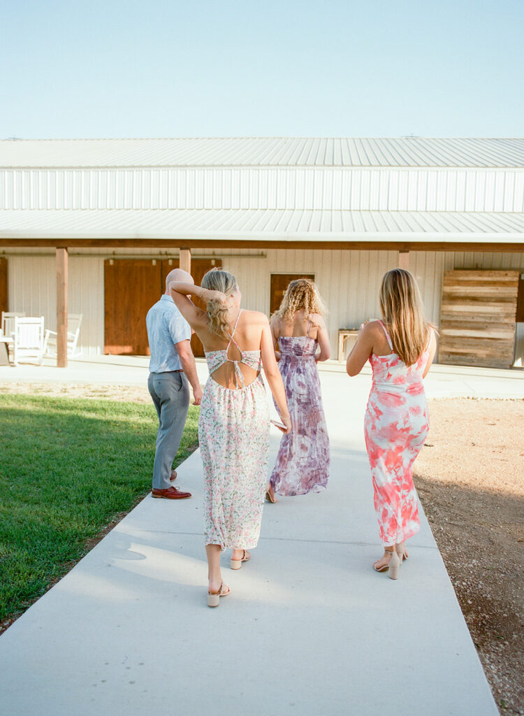 Bride walking with bridal party toward ceremony at The Allen Farmhaus in New Braunfels