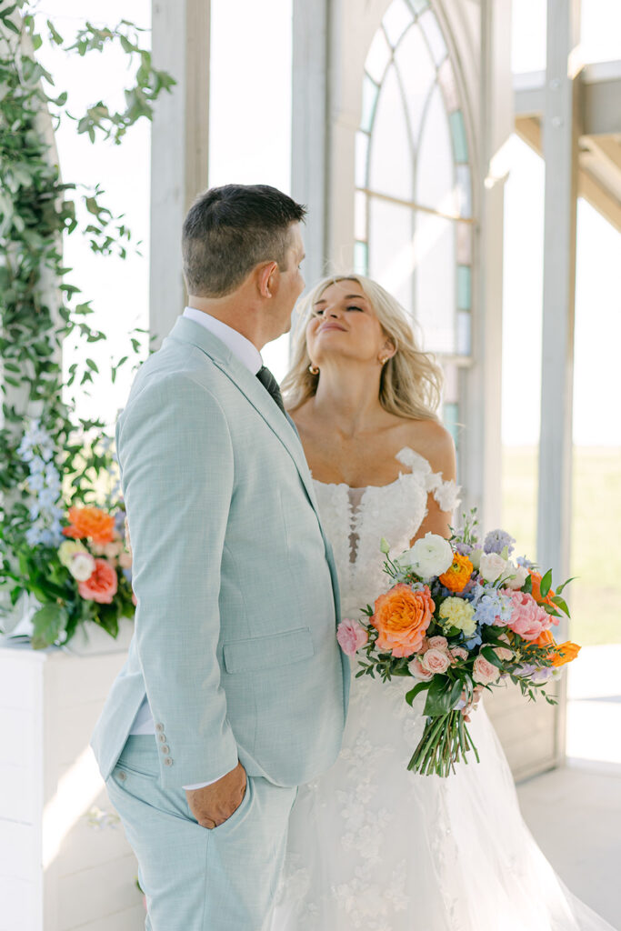 Bride and groom share a private moment under chapel light at The Allen Farmhaus