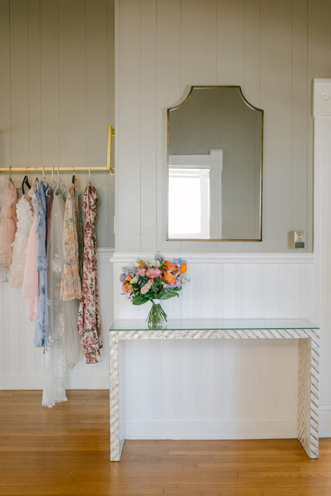 Bridal bouquet and dress with bridesmaid dresses in bridal suite at The Allen Farmhaus